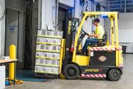 man riding a yellow forklift with boxes
